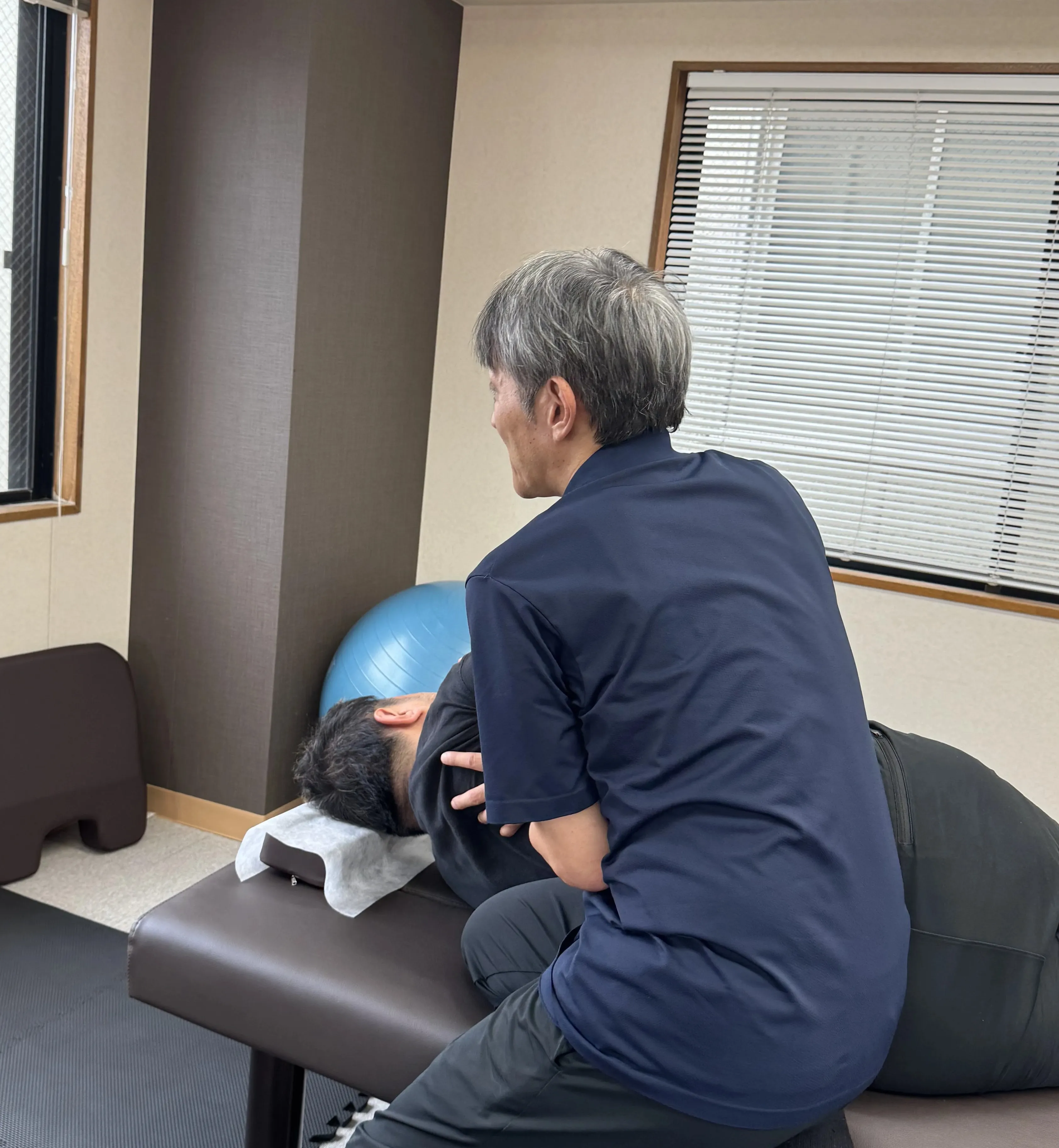 バーを使って姿勢を確認する理学療法士